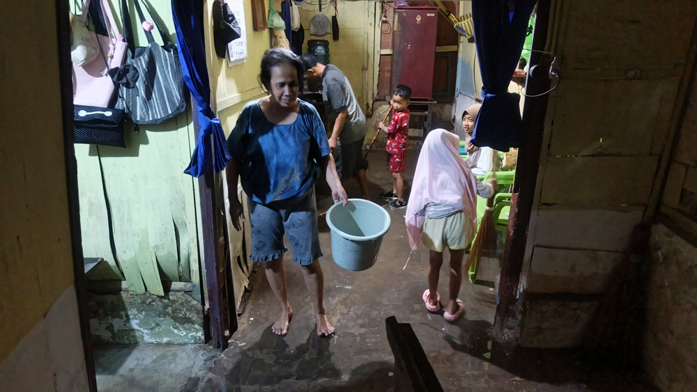 Warga Lingkungan Lebak, Kelurahan Tukangkayu, membersihkan rumahnya dari genangan air pada Kamis lalu (20/11).