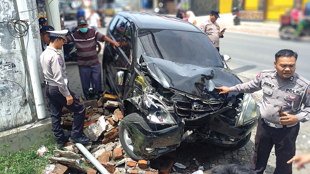 Anggota Unit Lantas Polsek Muncar mendatangi temat kejadian perkara tabrakan mobil dan sepeda motor di Jalan Raya Srono, Desa Kebaman, Kecamatan Srono, Senin (24/11).