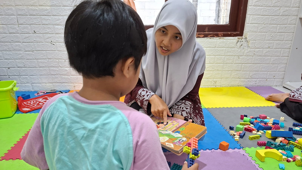 Nita membimbing anak-anak berkebutuhan khusus di Sekolah Ramah Inklusi di area Masjid Ahmad Dahlan Banyuwangi, Selasa (25/11).