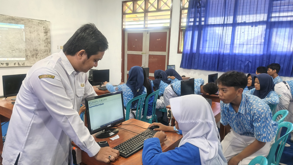 Salah satu guru sedang mengajar mapel TIK dengan memanfaatkan AI kepara murid di SMPN 2 Banyuwangi, Rabu (26/11).