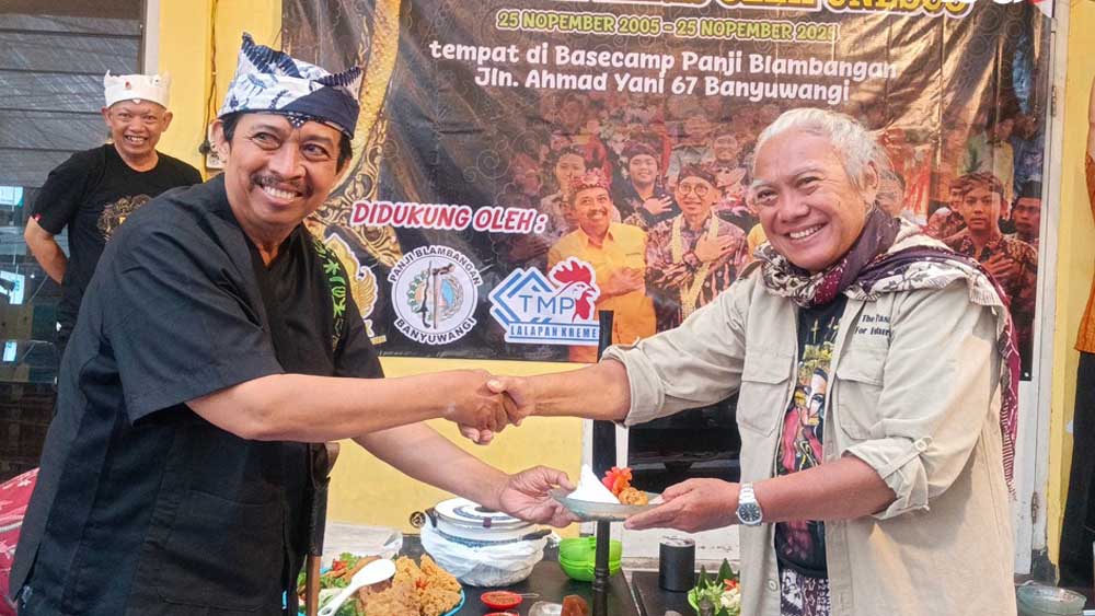 Ilham Triadi Nagoro menyerahkan potongan tumpeng kepada Budayawan sekaligus penulis cerita rakyat Banyuwangi Aekanu Hariyono di Basecamp Panji Blambangan pada Selasa (25/11).