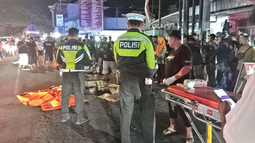 OLAH TKP: Petugas Unit Lantas Polsek Rogojampi memeriksa korban kecelakaan di simpang tiga Jalan Raya Pasar Rogojampi pada Rabu (26/11) malam.