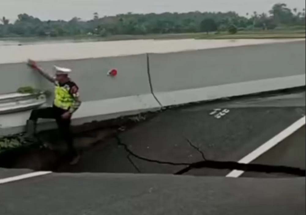 Petugas kepolisian tengah meninjau kondisi sesaat setelah jalan tol yang amblas di Km 41 ruas Tol Medan-Kualanamu-Tebingtinggi, Jumat (28/11/2025) siang.