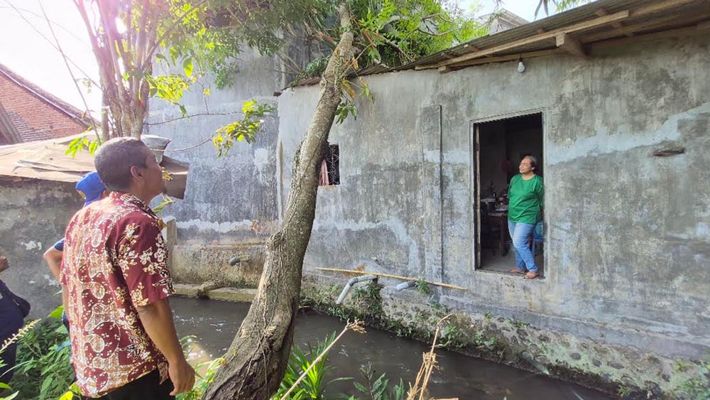 Petugas Damkarmat Sektor Genteng mengecek kondisi rumah milik warga yang tertimpa pohon di Dusun Kopen, Desa Gentengkulon, Kecamatan Genteng, Senin (1/12).