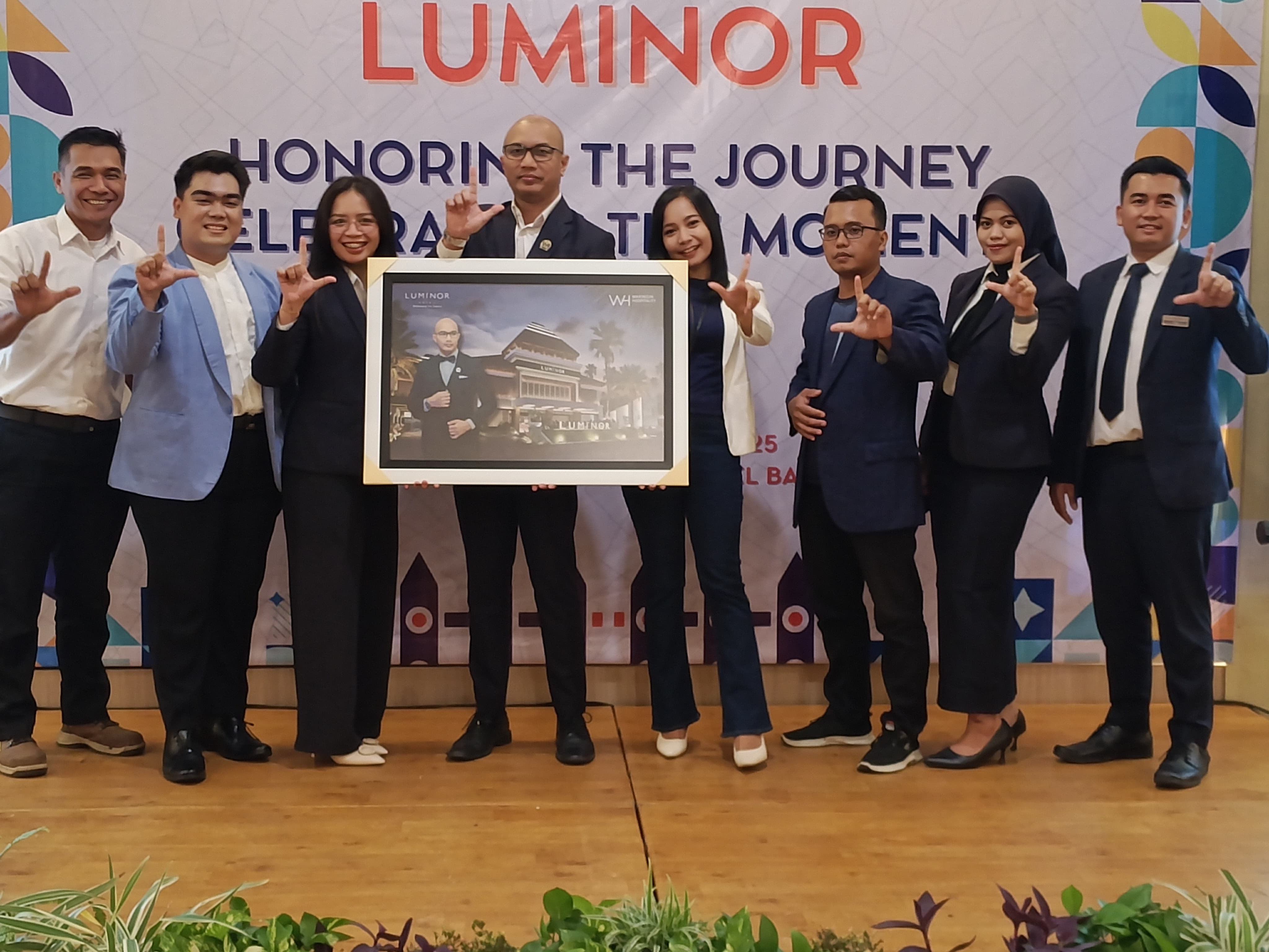 General Manager Ferdian Indrayana (empat dari kiri) mendapat kenangan berupa lukisan dari karyawan Luminor Hotel Banyuwangi, Selasa (2/12/2025).