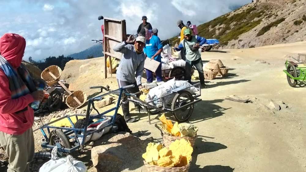 LEBIH MENJANJIKAN: Para pekerja pemikul belerang kini banyak yang beralih ke jasa ojek troli wisatawan Ijen.