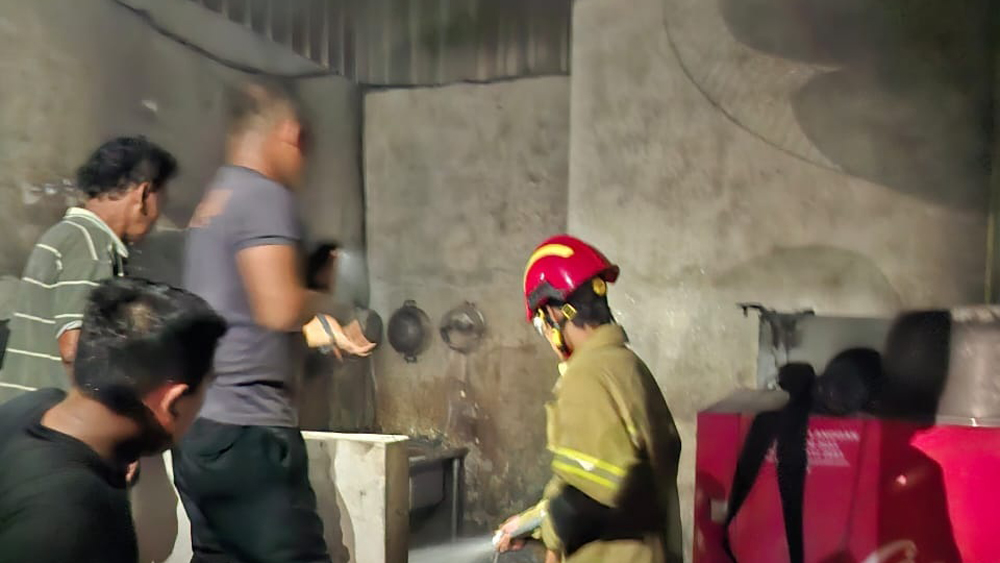 SEMPROT AIR: Petugas Damkarmat Sektor Srono memadamkan api di Dusun Tratas, Desa Kedungringin, Kecamatan Muncar, Kamis (4/12) malam.