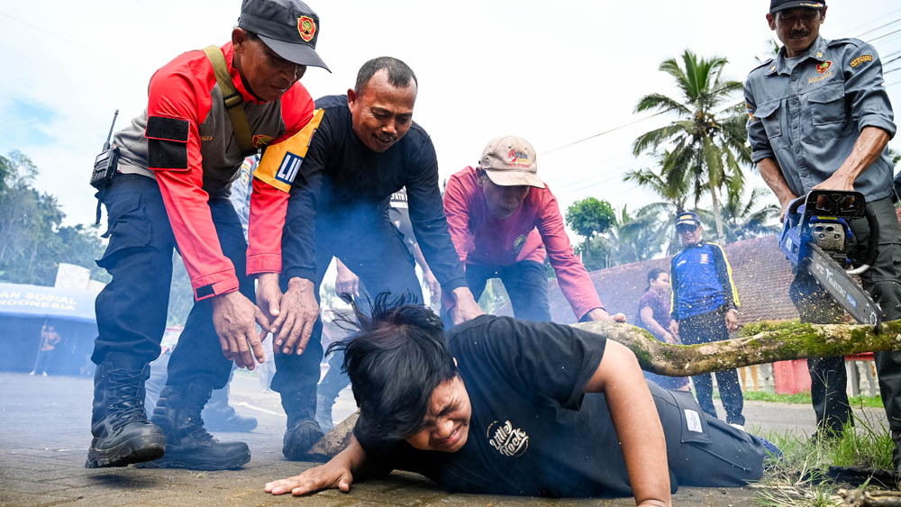 SIMULASI: Seorang warga yang tertimpa pohon diselamatkan oleh tim gabungan dalam simulasi penanganan bencana di Rest Area Jambu, Desa Tamansari, Licin, Senin (8/12).