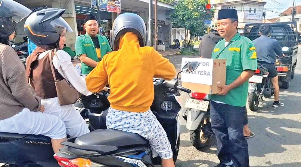 Pemuda Ansor Cluring penggalangan dana untuk korban banjir Aceh, Sumatera Barat, dan Sumatera Utara di simpang tiga Desa Benculuk, Kecamatan Cluring, Minggu (7/12).