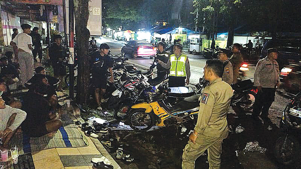 PATROLI MALAM: Petugas kepolisian bersama Satpol PP Gambiran menertibkan pengguna sepeda motor knalpot brong pada Sabtu malam (6/12).