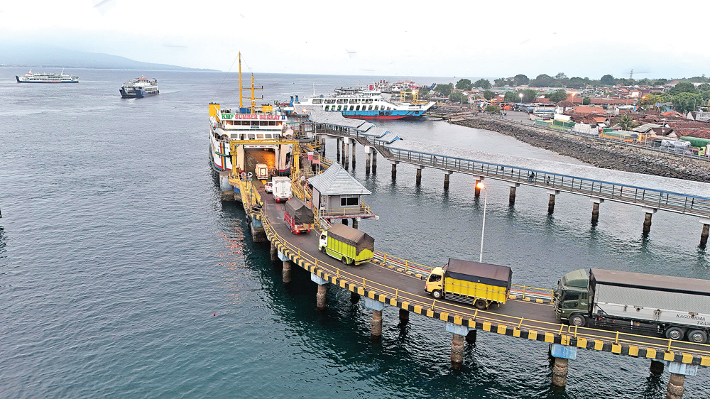 LANCAR: Sejumlah kendaraan logistik bersiap masuk kapal yang akan menyeberang ke Bali dari Pelabuha ASDP Ketapang.