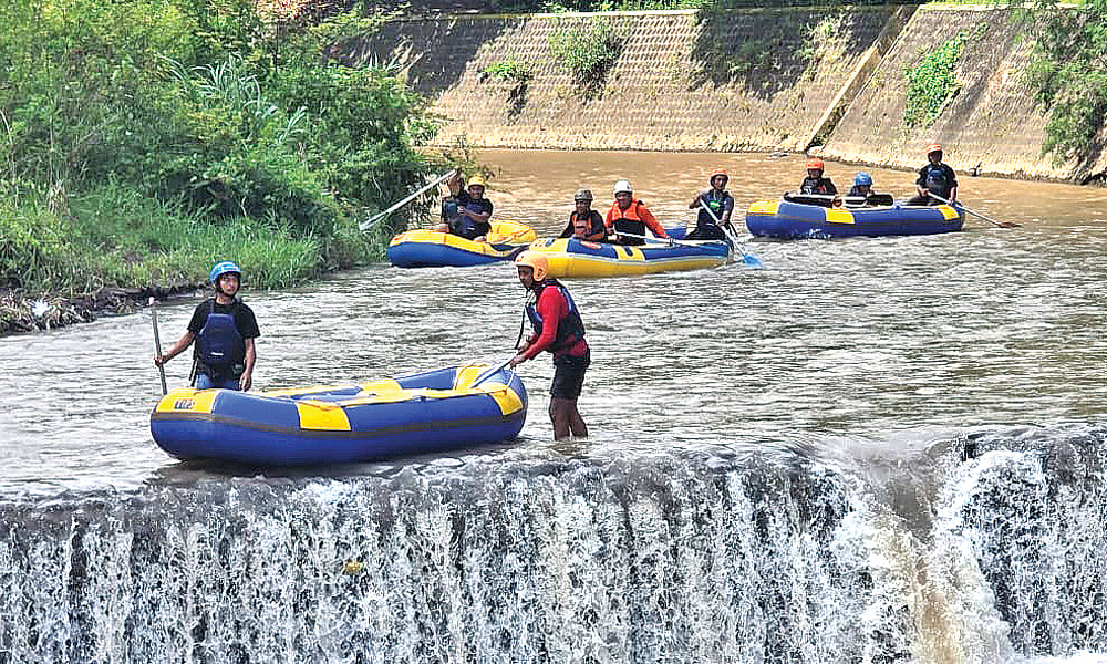 Petugas dari Polsek Songgon, Koramil Songgon, Basarnas, dan penggiat Arung Jeram menyisir Sungai Badeng menggunakan perahu karet, Minggu (7/12).