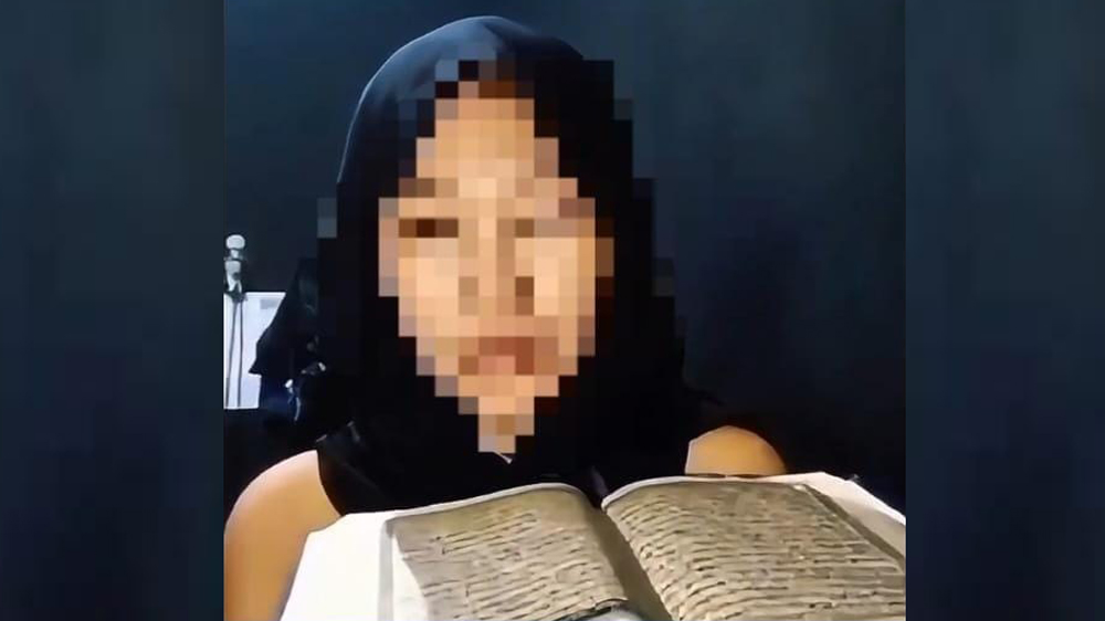 Beredar video perempuan mengenakan jilbab hitam menyebut Alquran sebagai benda sok suci sambil meludah.