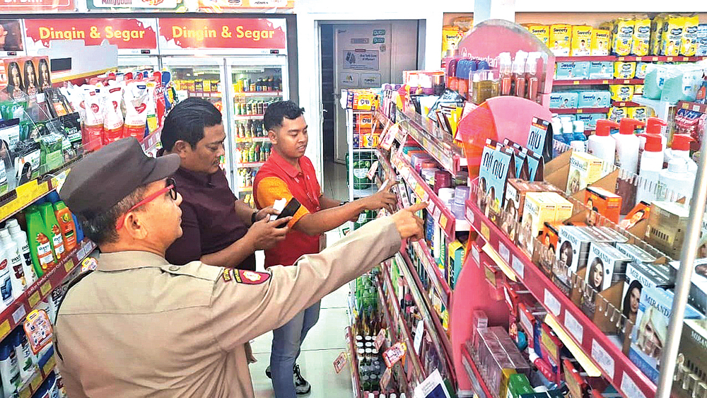 Anggota Unit Reskrim Polsek Genteng mengecek TKP pencurian di minimarket Murni Mart, Dusun Krajan, Desa Gentengwetan, Kecamatan Genteng, Rabu (10/12).