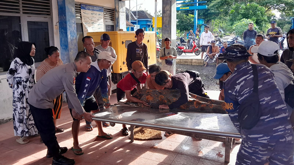 Anggota Polsek Purwoharjo dan TNI AL Pos Grajagan serta petugas Puskesmas Grajagan melakukan pemeriksaan korban tenggelam di Pelabuhan Grajagan, Selasa (9/12).