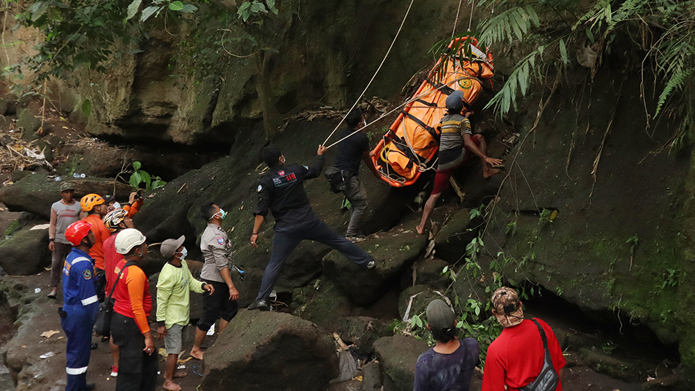 DITARIK LEWAT TEBING: Petugas gabungan mengevakuasi jenazah Ponirin dari dasar sungai di Desa Gladag, Kecamatan Rogojampi, Selasa (9/12).