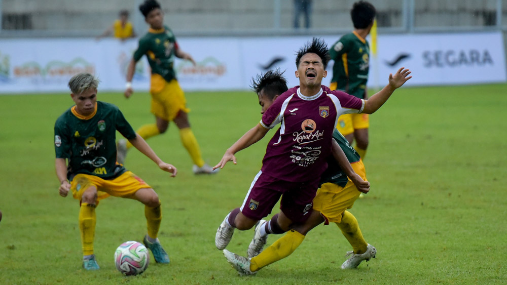 Pemain Persewangi Sandika P kena tackling keras pemain belakang PSSS dalam pertandingan Grup K Liga 4 Jatim di Stadion Diponegoro, Kamis (11/12).