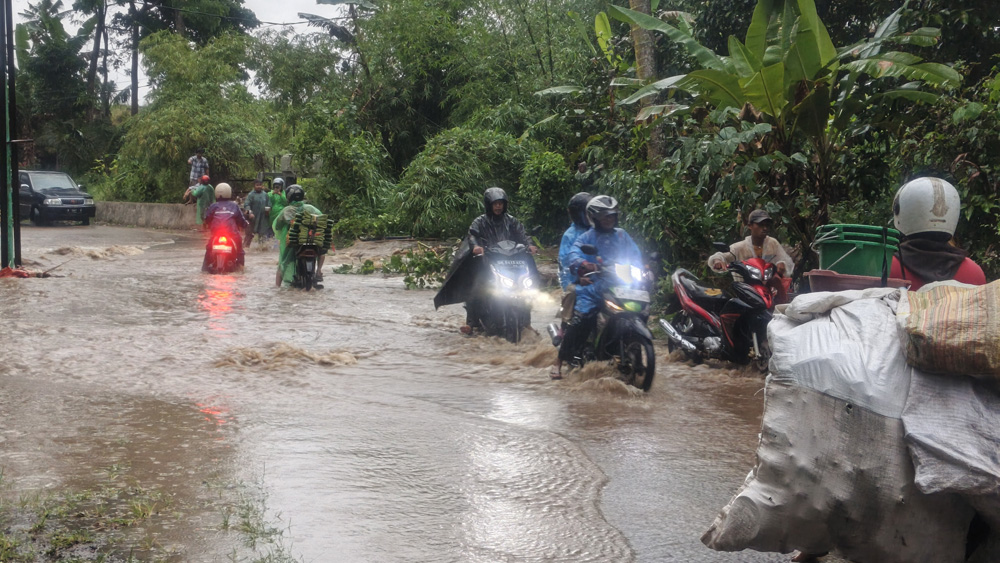JALANAN TERGENANG: Sejumlah warga yang melintasi genangan air di dekat Lembah Banjar Ijen pada awal November lalu (3/11).