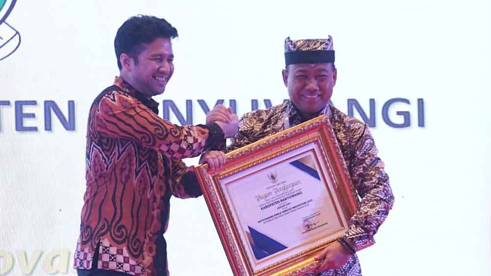 Wagub Jatim Emil Elestianto Dardak (kiri) menyerahkan penghargaan kepada Wabup Mujiono di Hotel Firefield by Marriott Surabaya, Jumat (12/12).