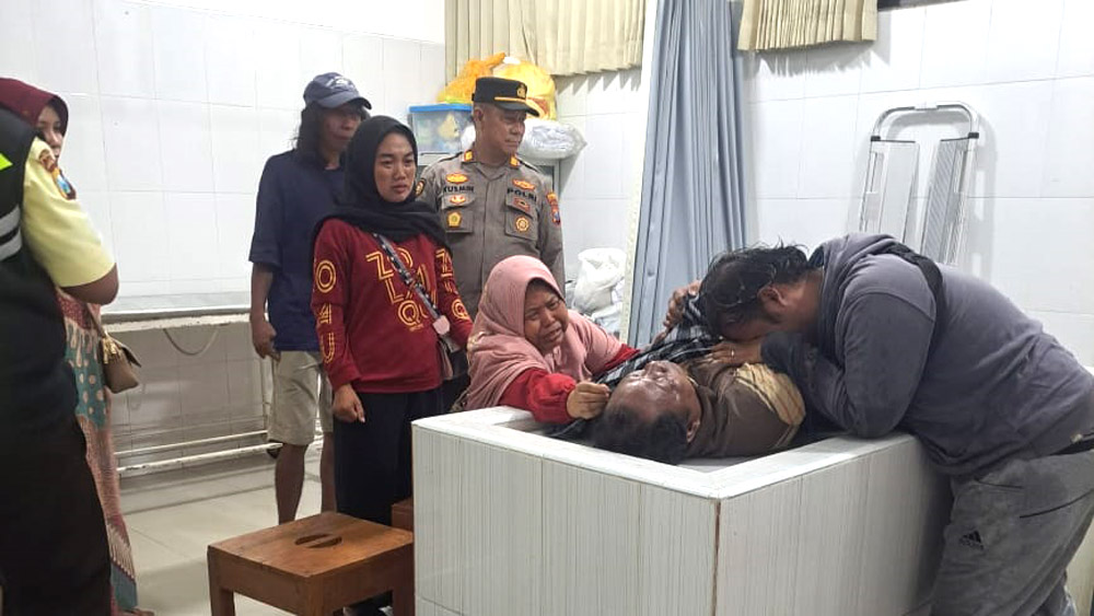 Keluarga korban memeluk jenazah Roni Hermanto di ruang mayat RSUD Blambangan, Sabtu (13/12).