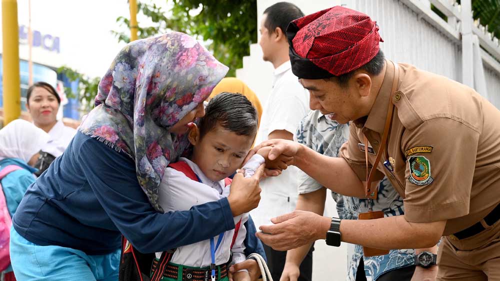 DIANTAR ORANG TUA: Kepala Dispendik Suratno menyambut kedatangan siswa pada awal tahun ajaran baru 2025/2026 beberapa waktu lalu (14/7).