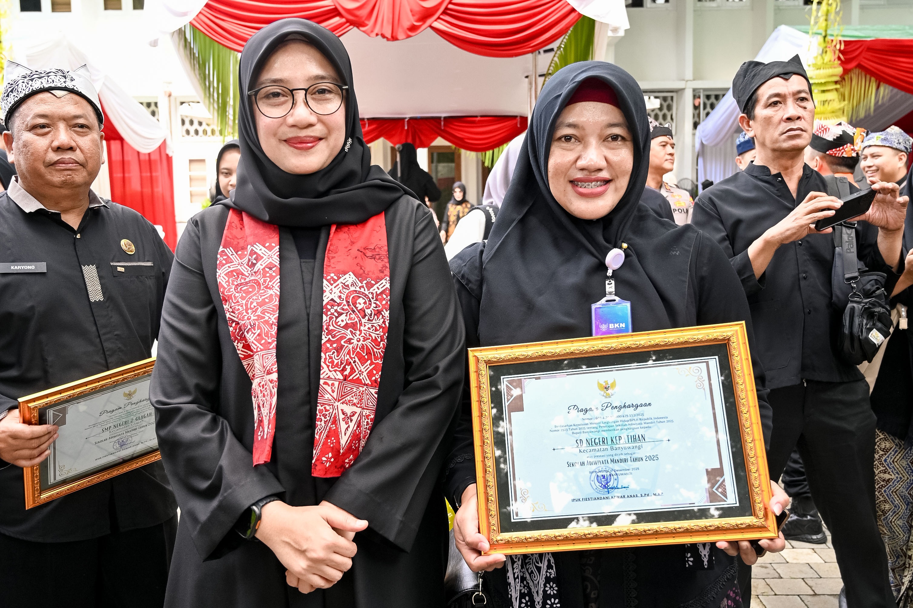 PERCONTOHAN: Kepala SDN Kepatihan Suliantari, S.Pd., SD menerima piagam penghargaan dari Bupati Ipuk Fiestiandani di halaman kantor Pemkab Banyuwangi Kamis (18/12).