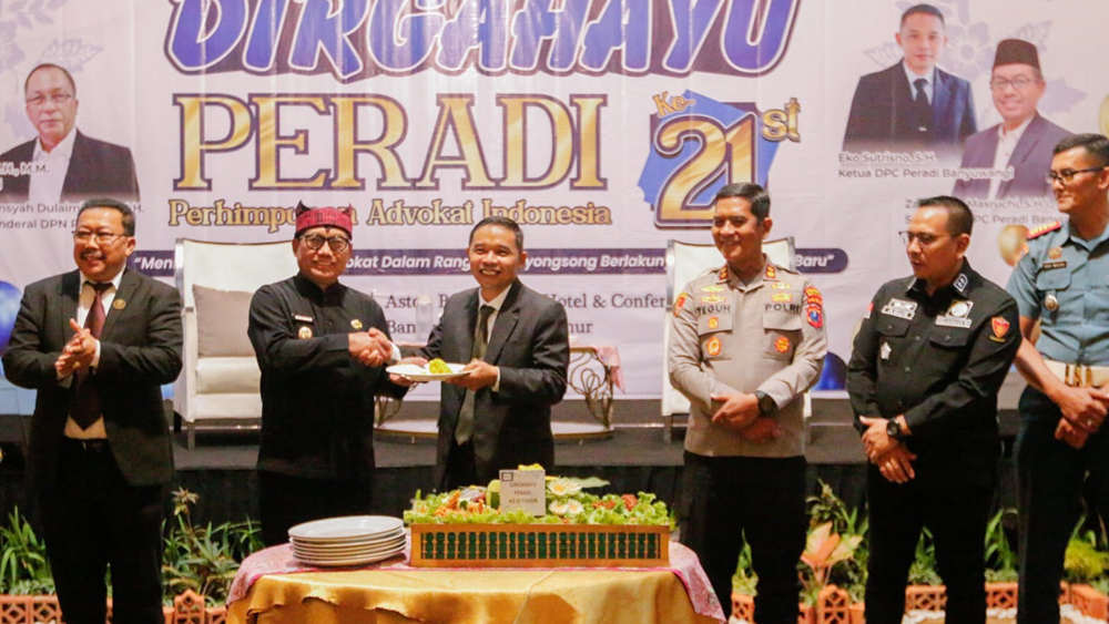 Ketua DPC Peradi Banyuwangi Eko Sutrisno menyerahkan potongan tumpeng kepada Wabup Mujiono dalam peringatan HUT ke-21 Peradi di Ballroom Hotel Aston, Kamis (18/12).