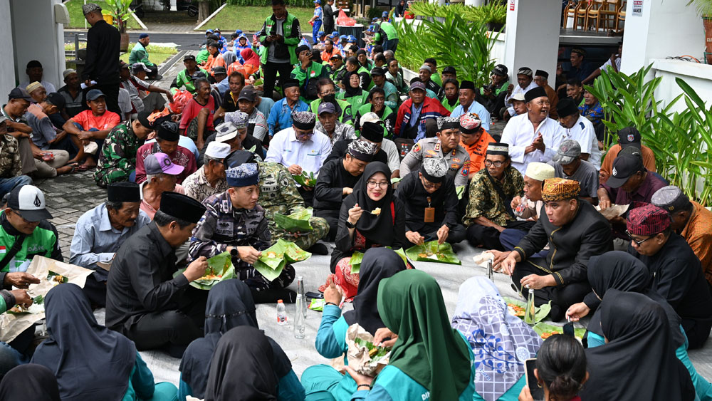 Bupati Ipuk bersama Forkopimda, tukang becak, driver ojol, dan petugas kebersihan menyantap nasi bungkus di halaman belakang kantor Pemkab Banyuwangi, Kamis (18/12).