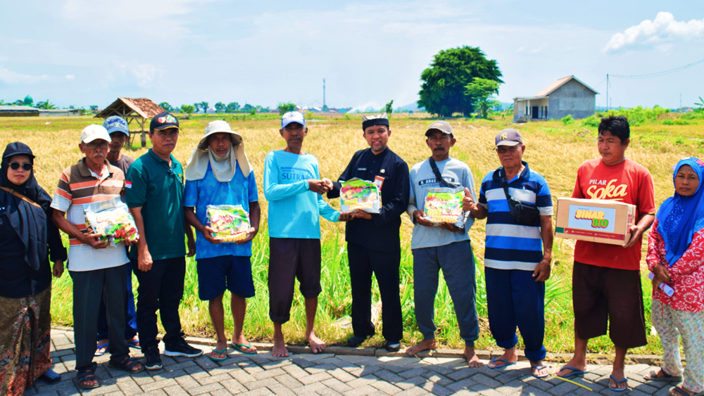 Kadispertan Banyuwangi Juanda membagikan pupuk hayati Sinar Bio ke petani yang terdampak banjir secara simbolis di Kecamatan Muncar, Kamis (18/12).