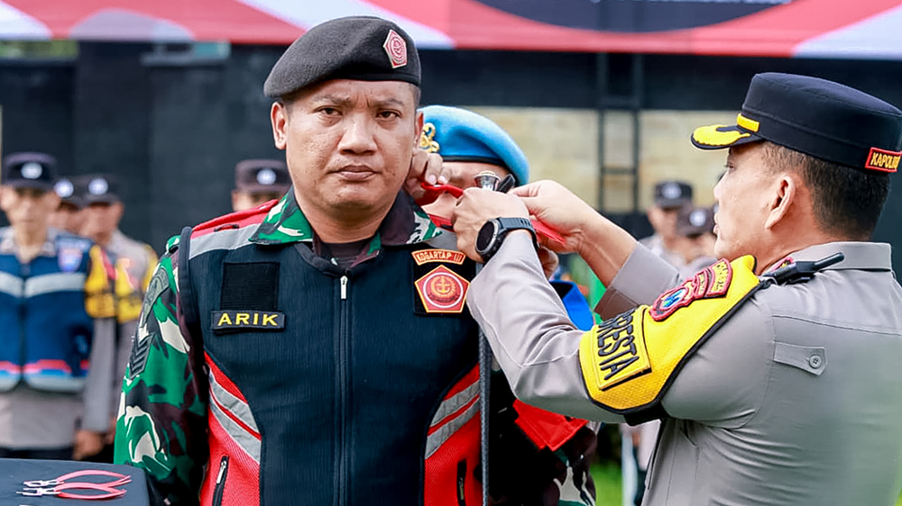 Kapolresta Kombespol Rama Samtama Putra memasang pita di pundak personel TNI dalam apel pasukan di Mapolresta Banyuwangi, Jumat (19/12).