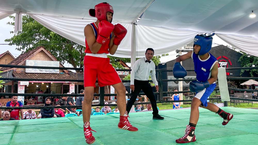 Atlet tinju bertanding di atas ring di kawasan Pantai Marina Boom Banyuwangi, Jumat (19/12).