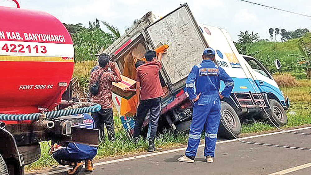 Petugas Damkarmat Genteng membantu mengevakuasi truk pengangkut susu segar yang terperosok ke parit di Dusun Sumbergayam, Desa Dasri, Kecamatan Tegalsari, Jumat (19/12).