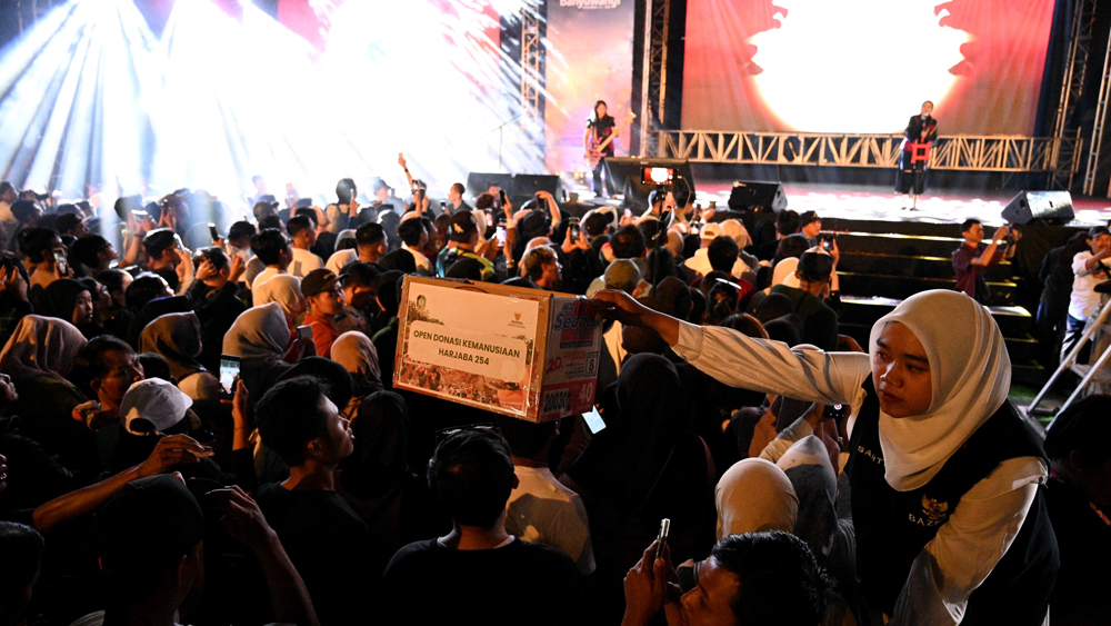 Petugas Baznas mengumpulkan donasi dari para penonton Konser Kemanusiaan yang dibintangi Kota Band di Gesibu Blambangan pada Sabtu malam (20/12).