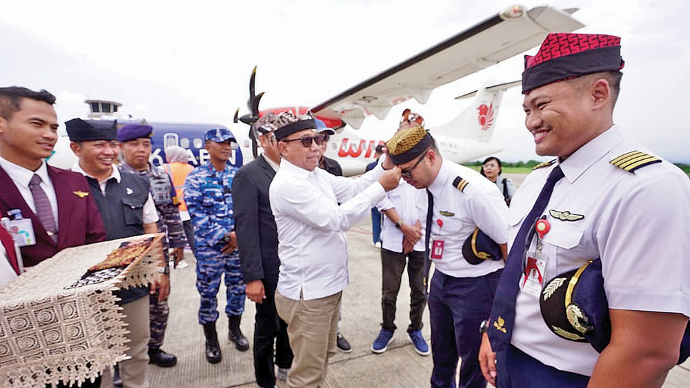 KHAS BANYUWANGI: Wabup Mujiono memakaikan udeng kepada pilot dan copilot pesawat Wings Air yang melayani rute BWX-LOP.
