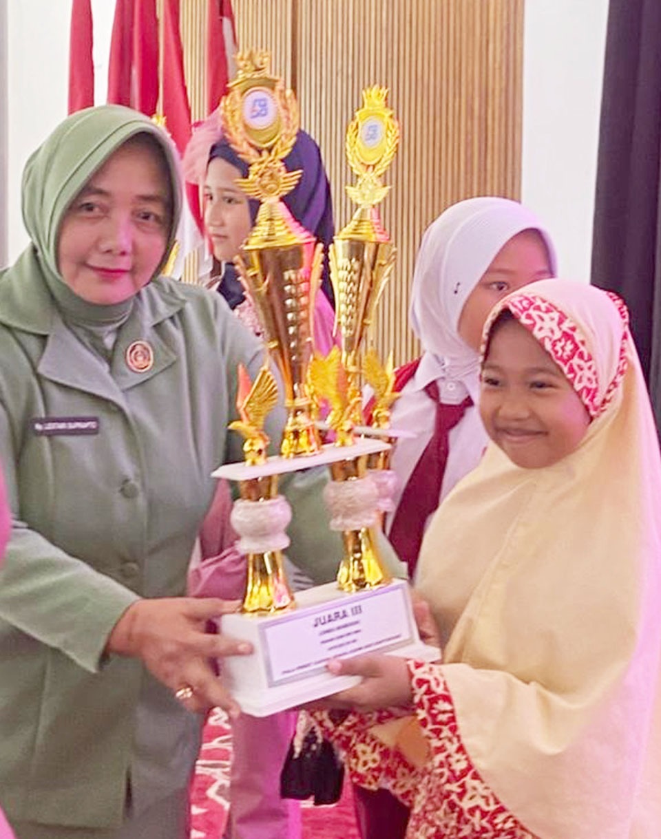 Devi Syifa Zaskya, siswi SD IT Al Uswah 2 Banyuwangi menerima Juara 3 Lomba Wawarah dari Perwakilan Persit Candra Kirana Kodim 0825 Banyuwangi Dian Rahmawati.