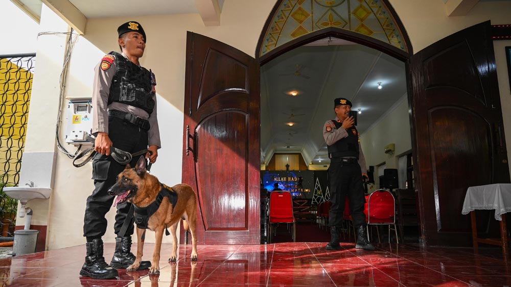 Anggota Samapta Polresta Banyuwangi menuntun anjing pelacak mengendus semua sudut ruang GKJW Banyuwangi, Rabu (24/12).