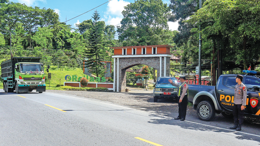 Anggota Polsek Kalibaru mengatur arus lalu lintas di jalan raya kawasan Gunung Gumitir, Kalibaru, Banyuwangi, Kamis (25/12).