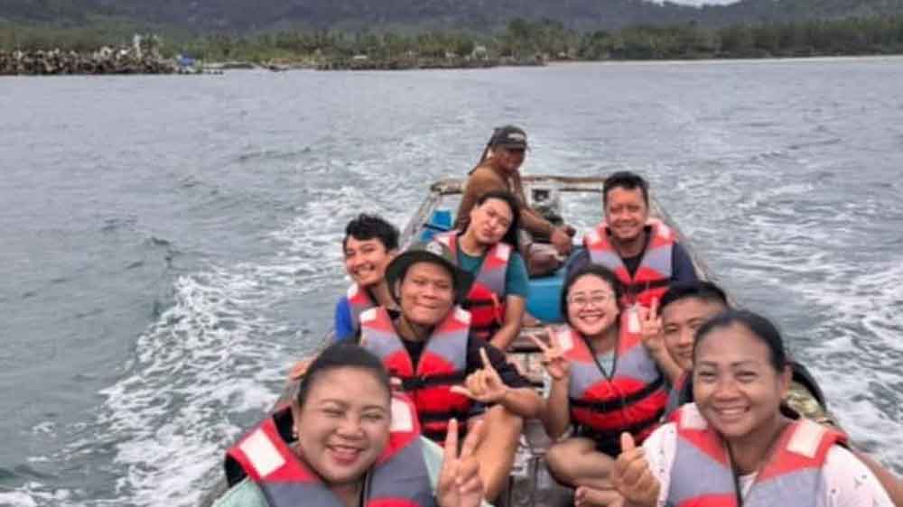 NAIK PERAHU: Wisatawan asal Surabaya menikmati keindahan Pulau Bedil, yang lokasinya tak jauh dari Pantai Mustika, Pesanggaran, Jumat (26/12).