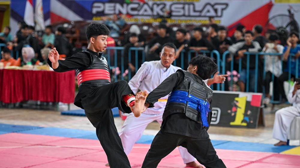 Atlet pencak silat bertarung dalam Kejurkab antarpelajar di GOR Tawangalun. Peserta Kejurkab 625 orang dari seluruh kelompok usia.