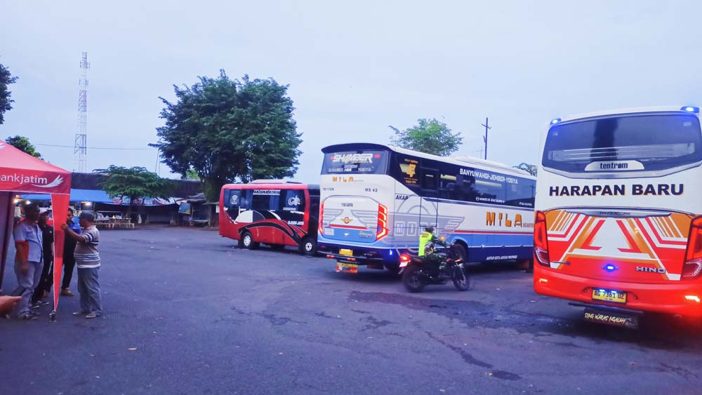 TUNGGU PENUMPANG: Kernet bersama sopir bus menunggu penumpang di Terminal Jajag, Kecamatan Gambiran, Sabtu (27/12).