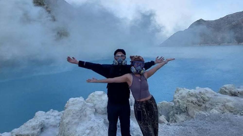 Wisatawan Ijen berfoto dengan latar belakang kawah sebelum muncul gas beracun pekan lalu.