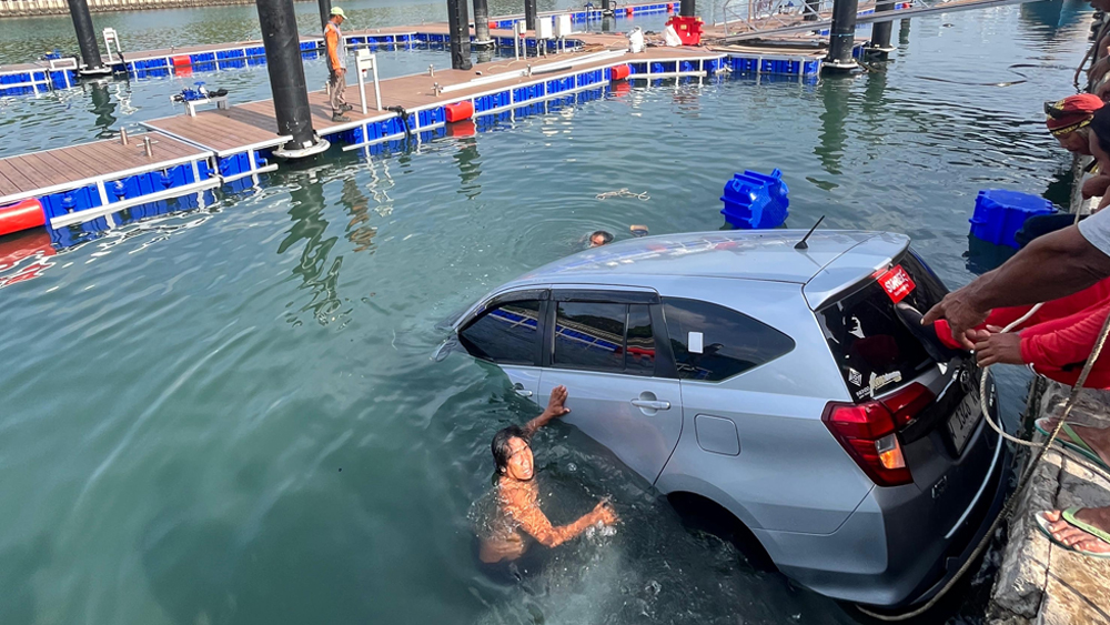 BISA DISELAMATKAN: Toyota Calya bernomor polisi W 1346 RW kecebur ke laut di kawasan plengsengan Pelabuhan Rakyat Marina Boom, Senin (29/12)