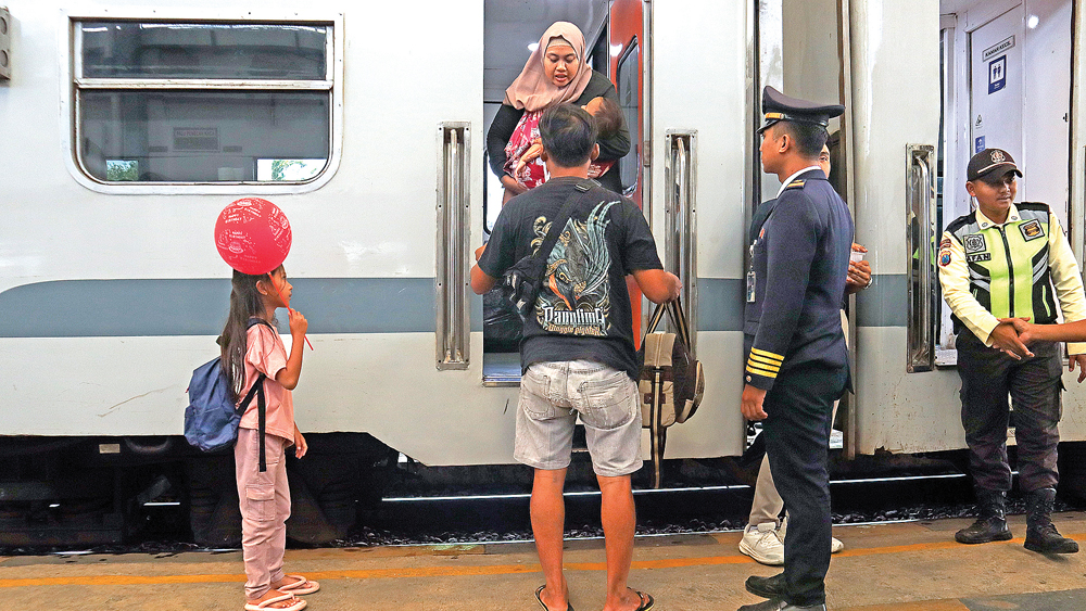 ANTRE: Penumpang hendak masuk kereta api di Stasiun Kalisetail, Desa/Kecamatan Sempu, Kamis (1/1).