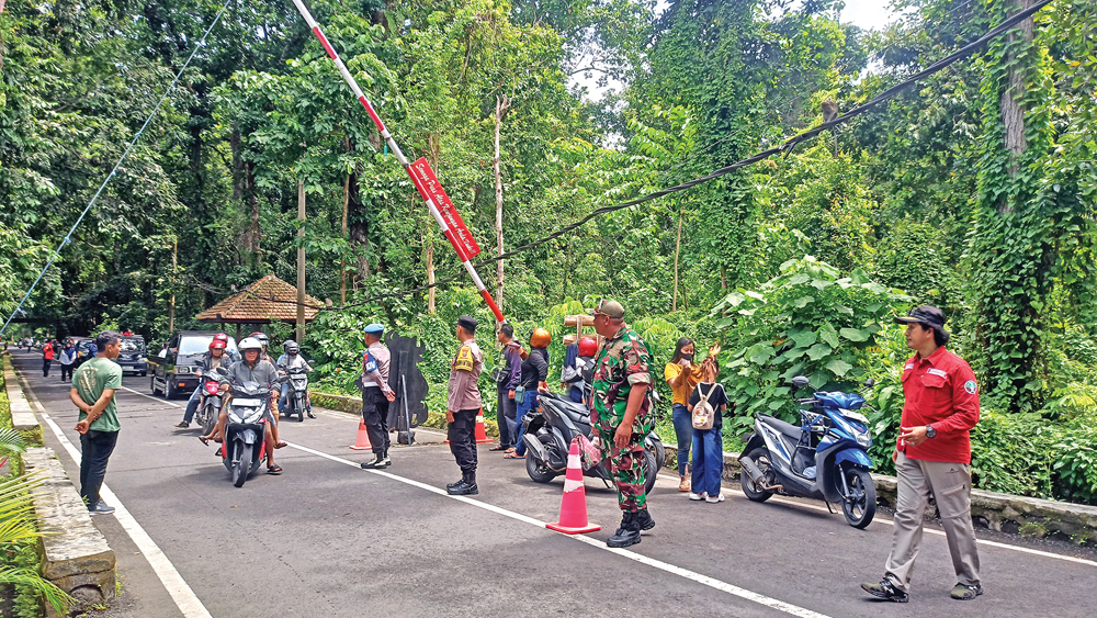 RAMAI PENGUNJUNG: Personel Kepolisian, TNI, dan petugas TNAP mengamankan jalur masuk Alas Purwo, Kamis (1/1).