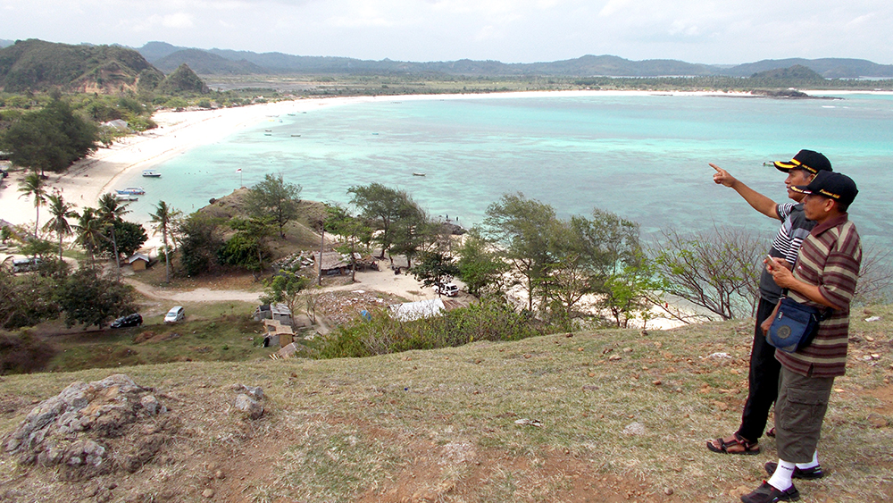 SPOT SNORKELING: Dua pelanggan Jawa Pos Radar Banyuwangi KH Astro Junaidi, Rahmat Sudiono menikmati view Tanjung Aan dari atas Bukit Merese.