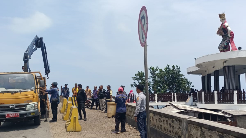 Petugas Dishub memasang barrier di tepi jalan depan Patung Gandrung Watudodol, Banyuwangi, Jumat (2/11).