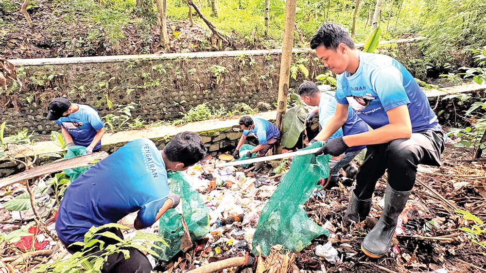 AWAL TAHUN: Forpimka Singojuruh bersama lintas elemen membersihkan sampah di Sungai, Jumat (2/1).