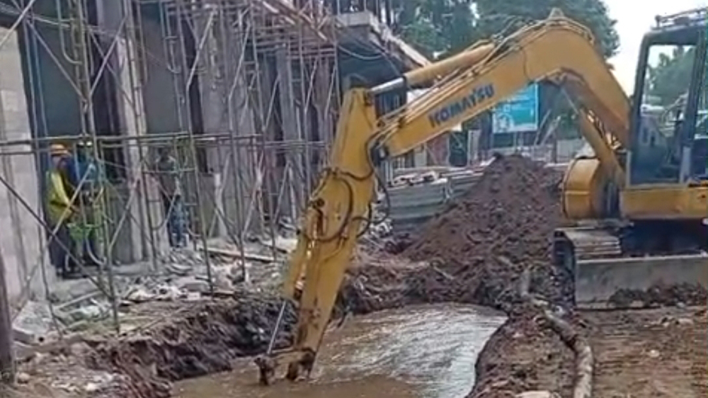 Air dari jaringan pipa PUDAM meluap setelah terkena hantaman ekskavator proyek revitalisasi pasar Banyuwangi, Sabtu lalu (20/12).