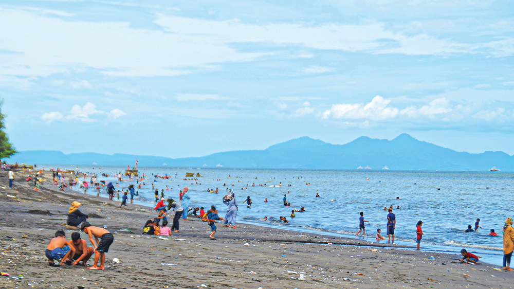 DIBANJIRI WISATAWAN: Pantai Gumuk Kantong di Desa Sumbersewu, Kecamatan Muncar, ramai pengunjung, Minggu (4/1).