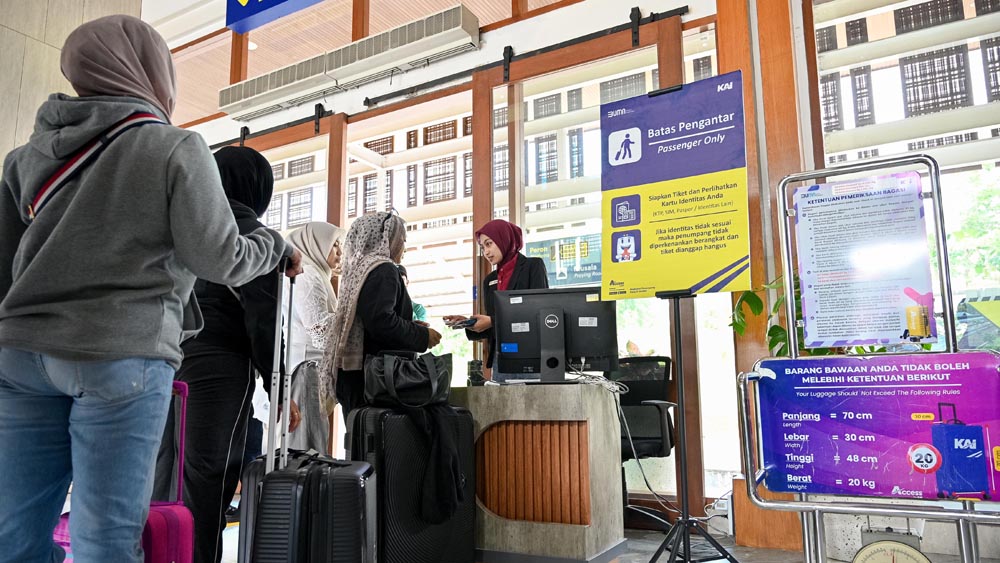 Penumpang menunjukkan tiket kepada petugas sebelum naik kereta api dari Stasiun Banyuwangi Kota, Selasa (6/1).